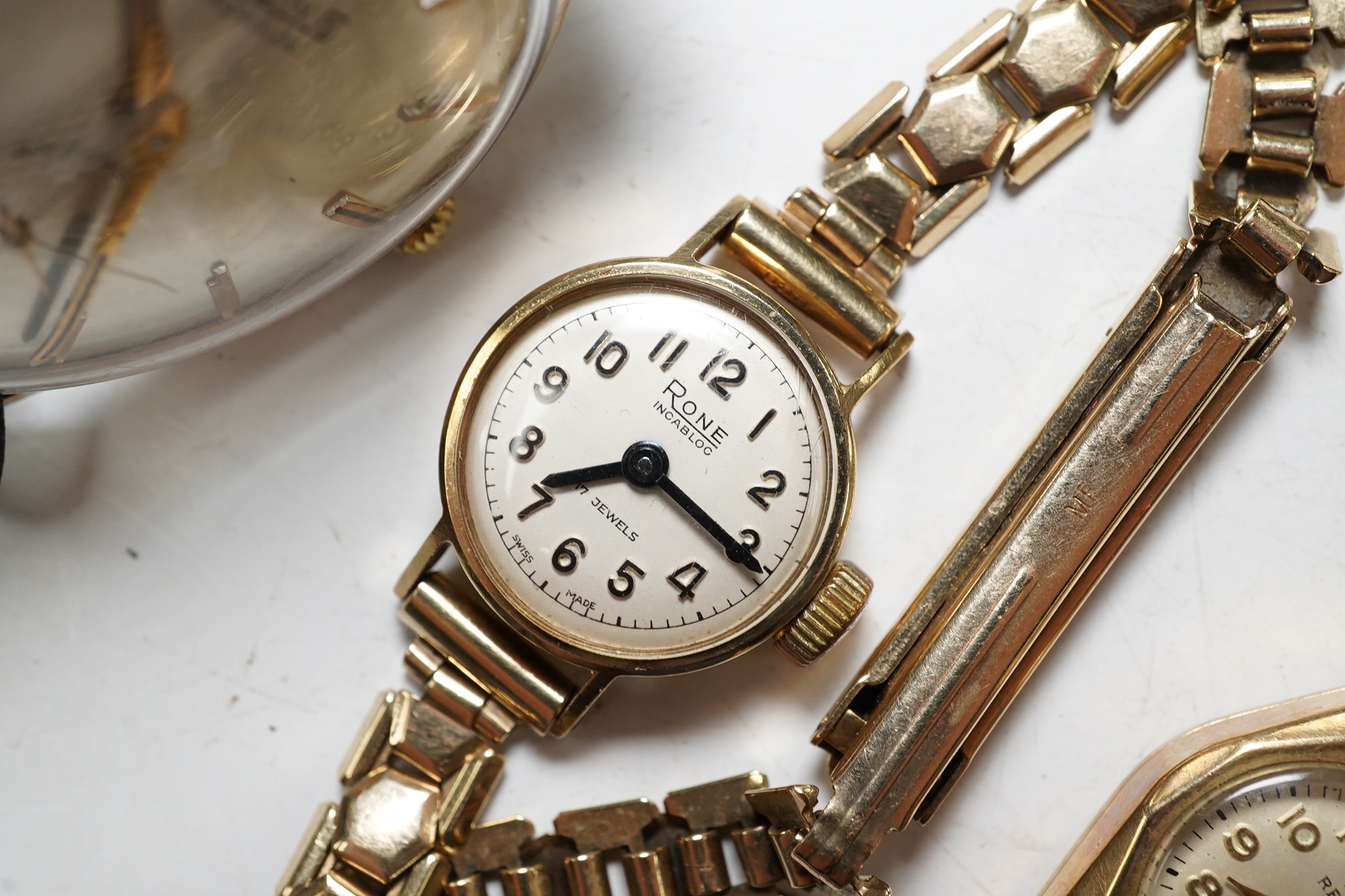 A ladies 9ct gold Rone Incabloc wrist watch with gilt strap and original box, a 9ct gold Record wrist watch with gold plated bracelet, and a gentleman's 9ct gold Rone Incabloc wrist watch in original box (3). Condition -